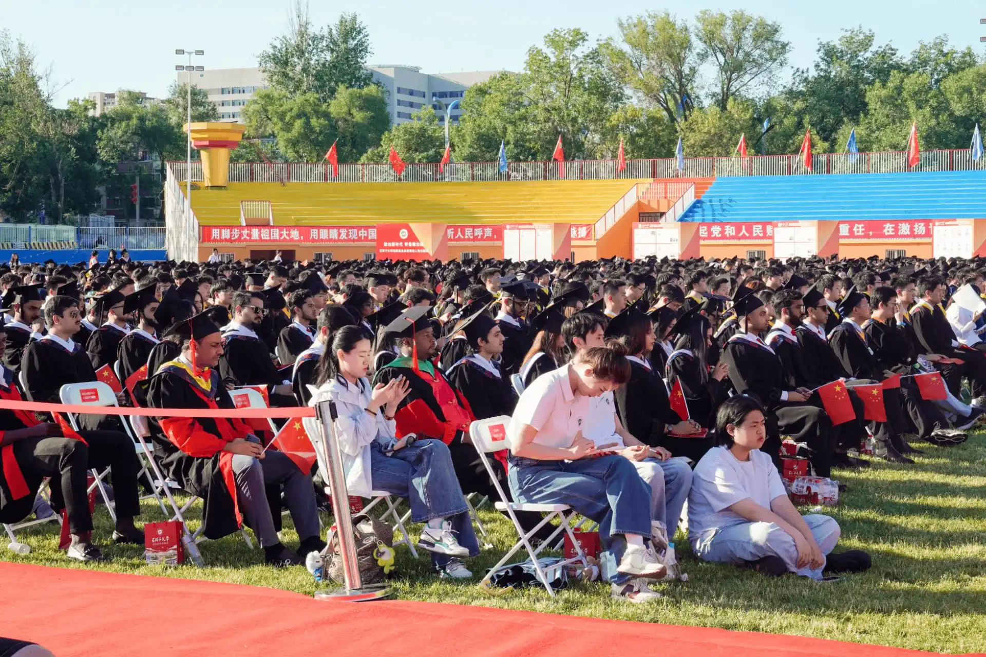 Row of students seated outdoors at university graduation event