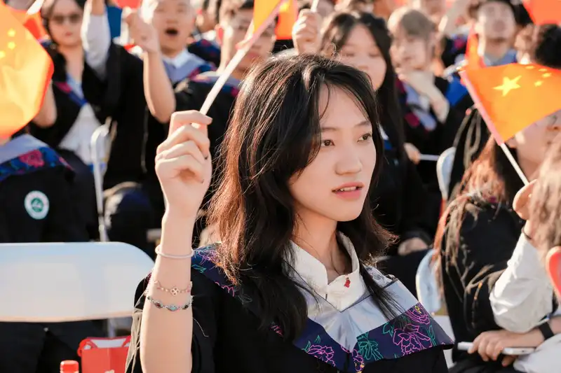 Female graduate taking a photo on stage with backdrop