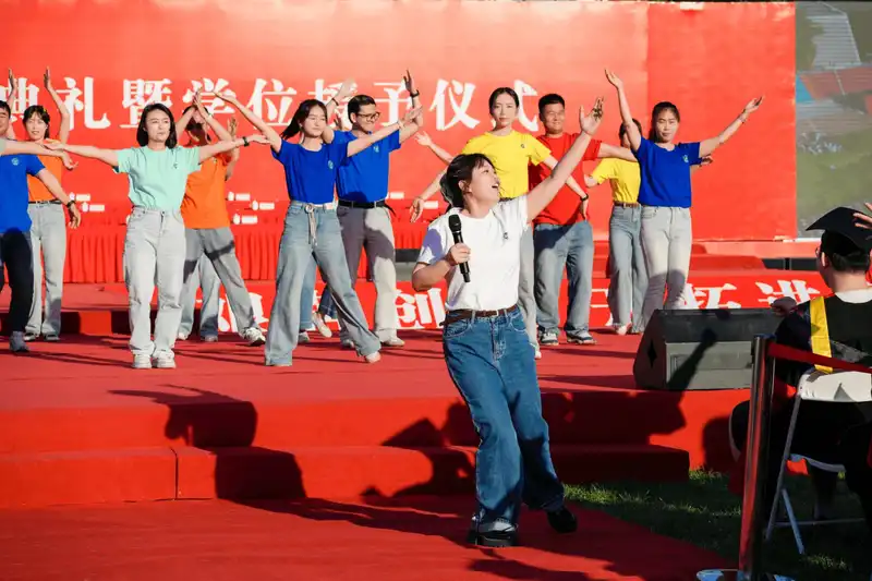 Students performing energetic dance routine on university stage